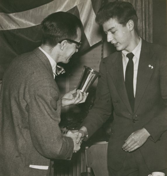 1955? 
Far Erik og en ukent modtager af en lille pokal.
Nøgleord: Erik